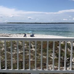 Gulf coast shoreline curving away past dunes and sea oats